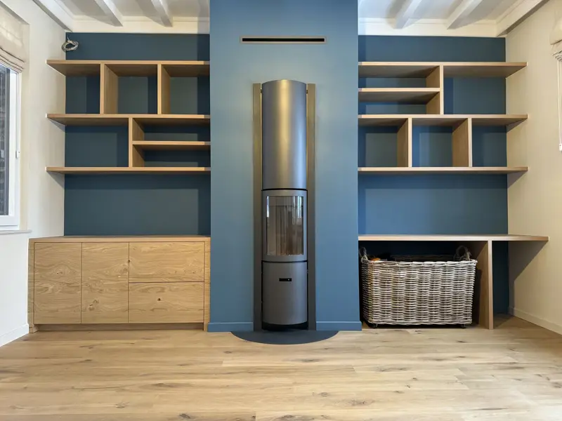 Meuble mural sur mesure bois et bleu autour d'un poêle